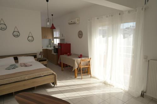 a bedroom with a bed and a table and a window at Aurora Studio Apt for Couples & Friends in Heraklio Town