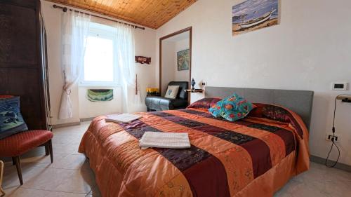 ein Schlafzimmer mit einem großen Bett und einem Stuhl in der Unterkunft Appartamento Luca e Giulia in San Bernardino