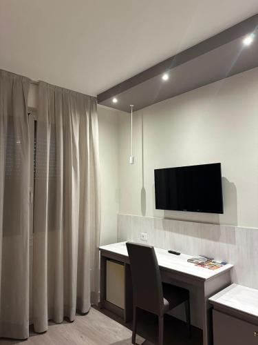 a room with a desk and a television on a wall at Confidence Hotel Europa in Cento