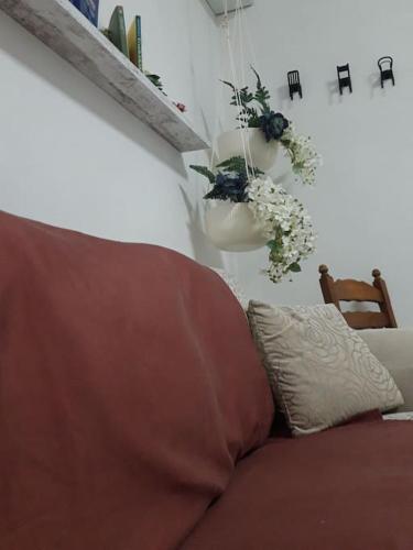 a living room with a couch and flowers on the wall at Affitti brevi Donna Rosa in Racalmuto