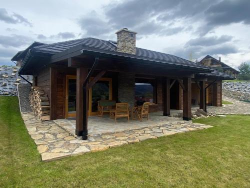 a log cabin with a roof and a patio at Bielańska Ostoja in Uście Gorlickie