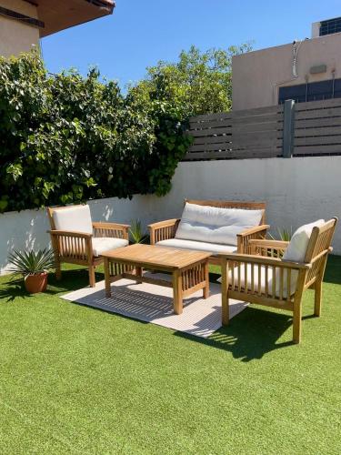 three benches and a wooden table on a lawn at Pool Villa Lagonisi 5min from Beach in Koropíon
