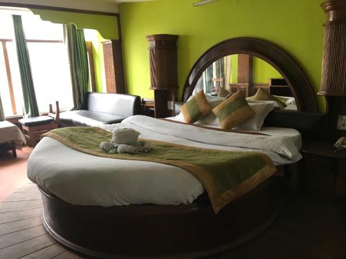 a bedroom with a large bed with a teddy bear on it at Kamya INN, Puri in Puri