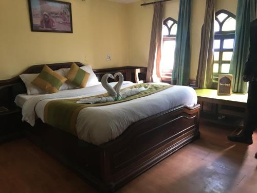 a bedroom with a bed with a swan on it at Kamya INN, Puri in Puri