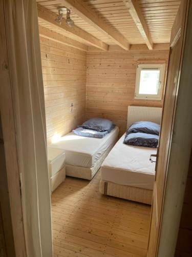 a small room with two beds in a wooden house at Luxe chalet Beek (gem Montferland) bosrijk, rust en privacy in Beek