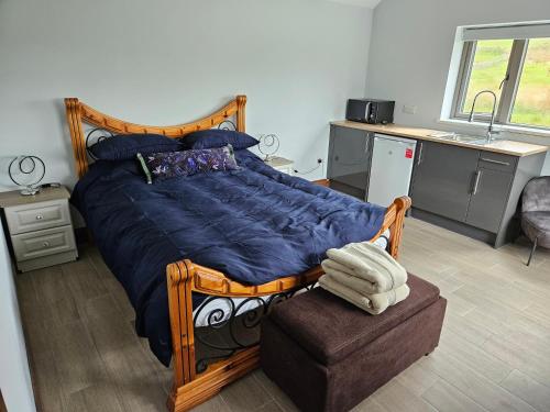 a bedroom with a large bed with a blue comforter at Suaimhneas in Lahinch