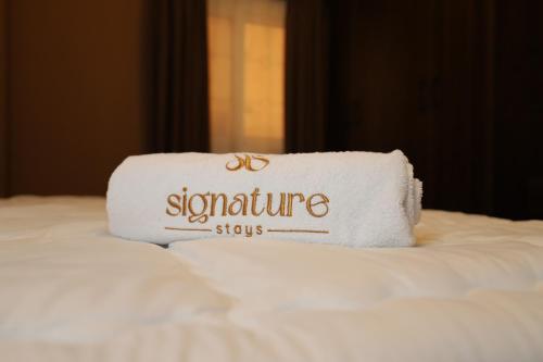 a towel sitting on top of a bed at Signature Stays: Modern Chic Apt in Cairo