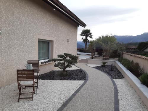 a garden with a walkway next to a house at Un petit coin de paradis à Haute Jarrie in Jarrie
