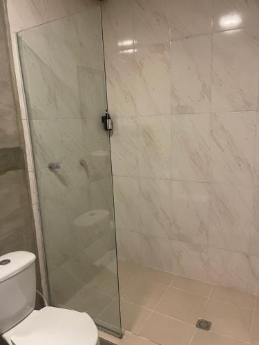 y baño con ducha de cristal y aseo. en Abel Boutique House, en Cartagena de Indias