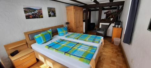 a bedroom with two beds with blue and green pillows at Wein-und Gasthof Zipf in Miltenberg