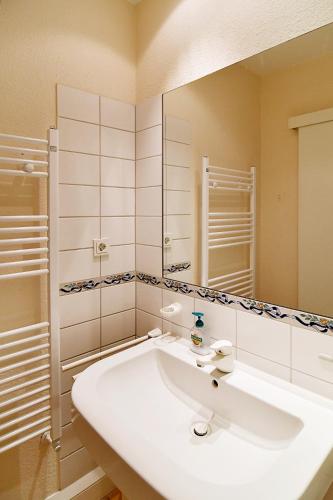 a white bathroom with a sink and a mirror at Strandklause-App-04 in Seebad Bansin in Heringsdorf