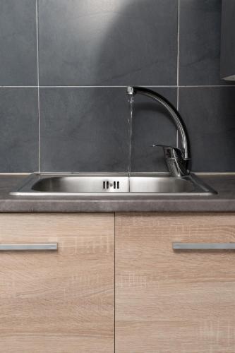 a stainless steel kitchen sink with a faucet at Panos Marina Apartment P1 in Porto Rafti