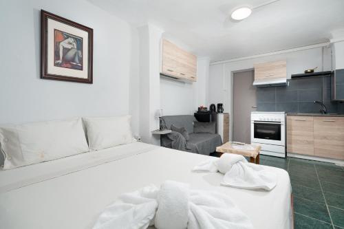 Un dormitorio con una cama blanca y una cocina. en Panos Marina Apartment P1, en Porto Rafti