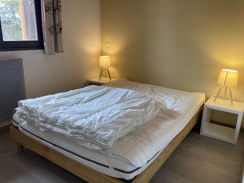 une chambre avec un lit avec une couette blanche dans l'établissement Appartement cosy 6 pers, centre Alpe d'Huez, proche pistes/activités, balcon sud - FR-1-405-359, à Huez