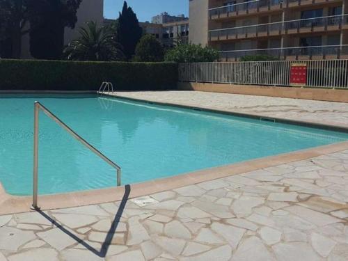 une piscine avec de l'eau bleue dans un immeuble dans l'établissement Appartement avec Piscine et Tennis, 2 Ch, Terrasse, Parking, WiFi - Proche Plage, Le Lavandou - FR-1-251-794, au Lavandou