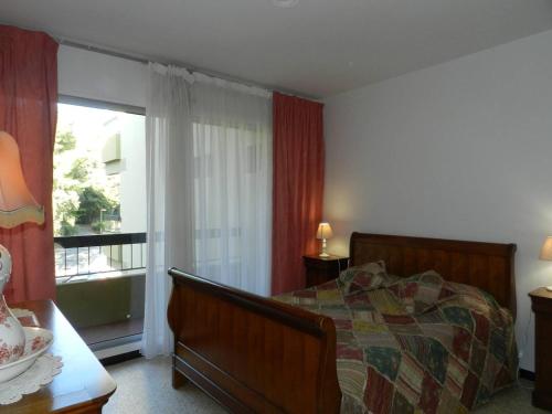 une chambre avec un lit et une grande fenêtre dans l'établissement Appartement 2 pièces avec piscine, proche plage et commerces - Bormes-les-Mimosas - FR-1-251-796, à Bormes-les-Mimosas