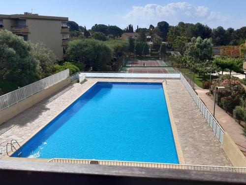 - une grande piscine bleue au-dessus d'un bâtiment dans l'établissement Appartement 2 pièces avec piscine, proche plage et commerces - Bormes-les-Mimosas - FR-1-251-796, à Bormes-les-Mimosas