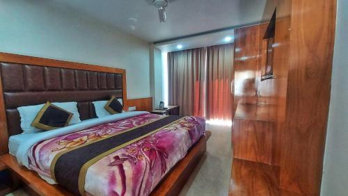 um quarto com uma cama grande e uma cabeceira em madeira em HOTEL INDIA HOUSE em Dharamshala