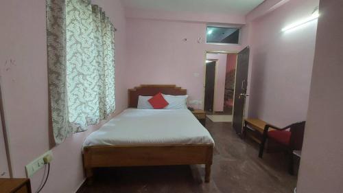 a bedroom with a bed with a red pillow on it at Gautam Villa Home Stay Varanasi in Varanasi