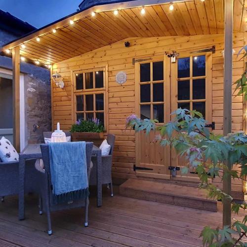 a patio with a table and chairs on a wooden deck at Beatrice Cottage in Richmond