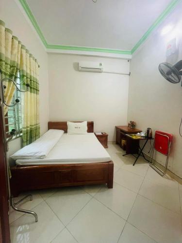 a bedroom with a bed and a red chair at HOTEL 88 in Yên Minh