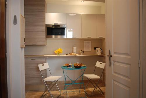 - une petite cuisine avec une petite table et des chaises dans l'établissement SORTIE 44 - NEWLY renovated 1 bedroom, center of old Antibes, à Antibes