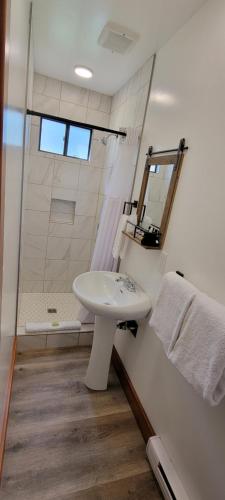 a white bathroom with a sink and a shower at Crandell Mountain Lodge in Waterton Park