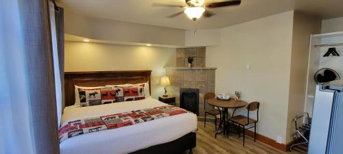 ein Schlafzimmer mit einem Bett und einem Tisch in einem Zimmer in der Unterkunft Crandell Mountain Lodge in Waterton Park