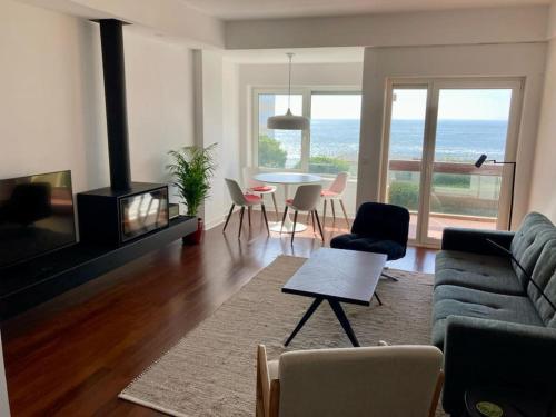 a living room with a couch and a table with chairs at Oceanview 4 U - Close to Lisbon! in Oeiras
