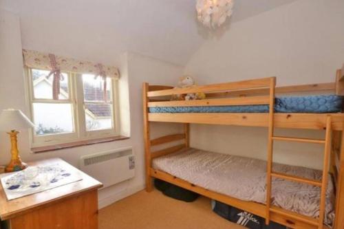 a room with two bunk beds and a desk at Lime Cottage in Minehead