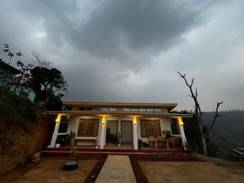 een huis aan de zijkant van een berg bij Orange Bari Farmstay in Darjeeling