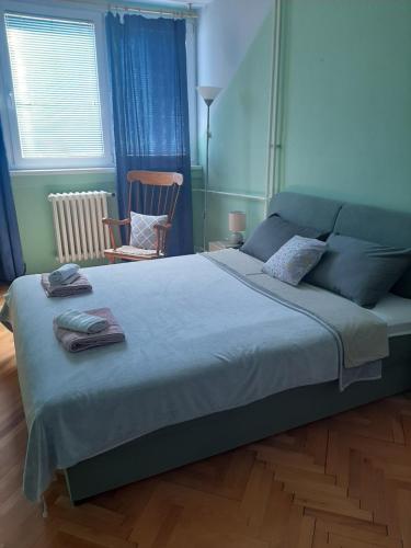 a bedroom with a large bed with two towels on it at Apartman Oskar in Bor