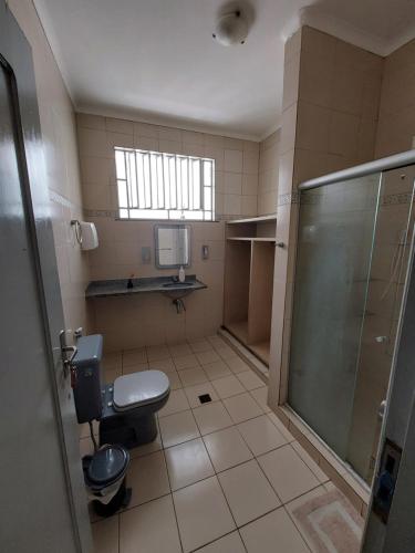 a bathroom with a toilet and a shower at Guará Hostel in São Luís