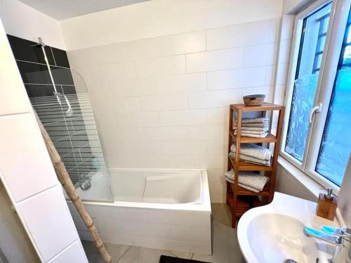 uma casa de banho branca com uma banheira e um lavatório em Villa avec piscine em Montpellier
