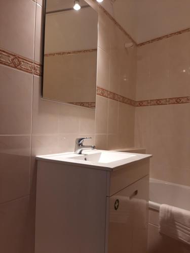 un bagno con un lavandino, uno specchio e una vasca di Lugar do Sonho Apartamento a Cercal