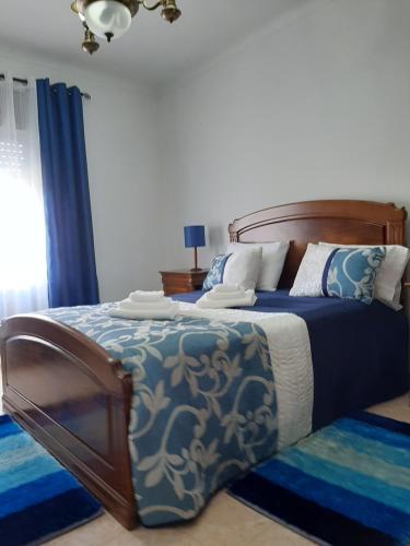 una camera da letto con un letto grande con lenzuola blu e bianche di Lugar do Sonho Apartamento a Cercal