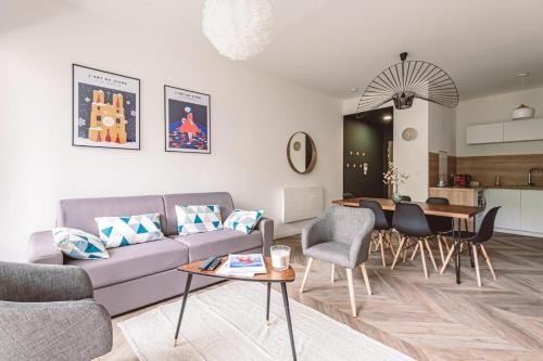 un salon avec un canapé et une table dans l'établissement HENRI au pied de la cathédrale., à Reims