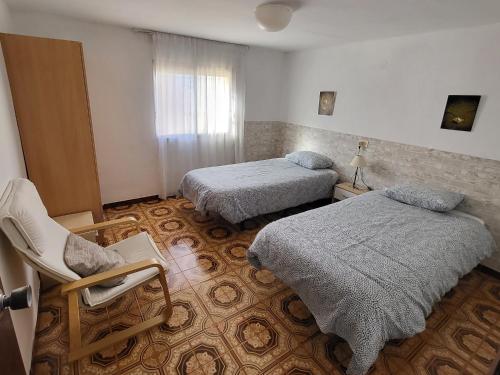 a room with two beds and a chair in it at villa berta in Vinarós