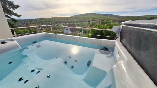 bañera de hidromasaje en el balcón con vistas en Hillside Cottage en Pécs