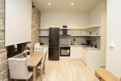 a kitchen with a table and a dining room at MONOPATI HOUSE in Mouzákion