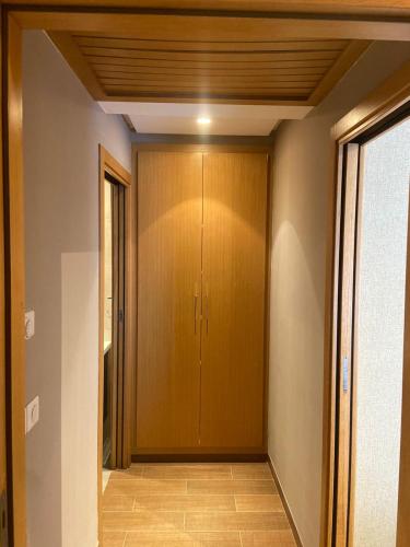 um corredor com uma porta de madeira numa casa em Appartement en résidence tunis em Tunes