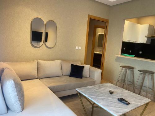 uma sala de estar com um sofá branco e uma mesa em Appartement en résidence tunis em Tunes