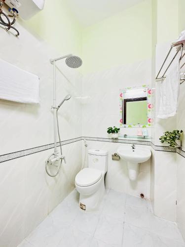 a white bathroom with a toilet and a sink at GUEST HOUSE PHÚ XUÂN in Thôn Lại Thê