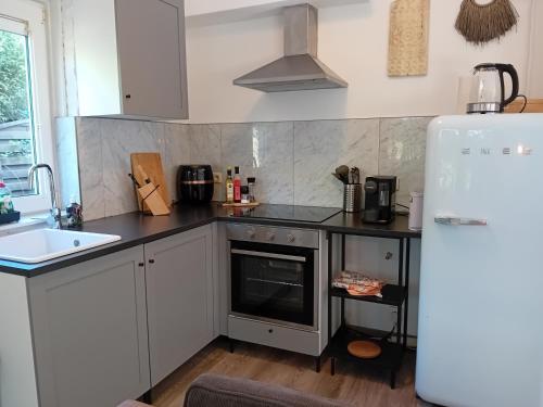 a kitchen with a white refrigerator and a sink at Vakantiehuis vlakbij Duitse grens in Beek