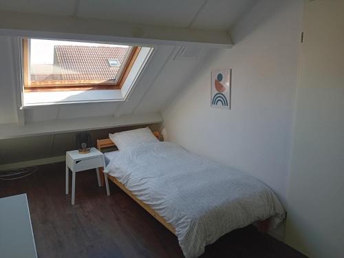 Habitación pequeña con cama y ventana en Vakantiehuis vlakbij Duitse grens, en Beek