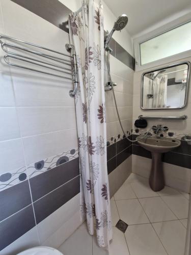 een badkamer met een douchegordijn en een wastafel bij Етаж от къща с двор in Boergas