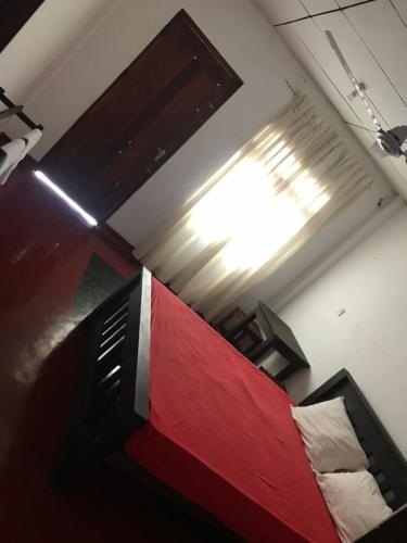 a room with a bed with a red and white at Everest Rooms in Piliyandala