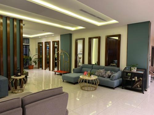a living room with blue couches and tables at Sky Hotel in Aqaba