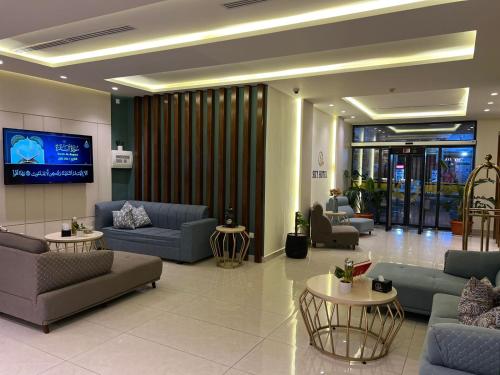 a lobby with couches and tables and a flat screen tv at Sky Hotel in Aqaba