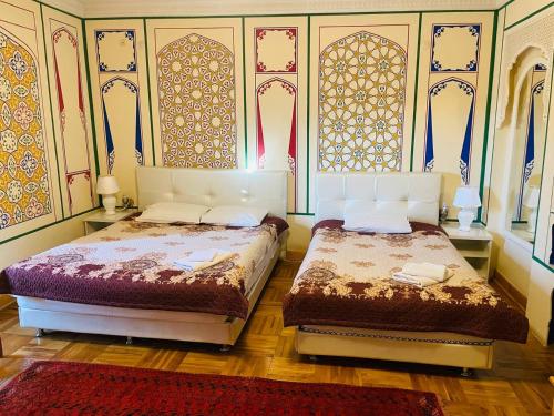 Duas camas sentadas uma ao lado da outra num quarto em Hotel Chorminor Old Premium Est-Since 2003 Mekhtar anbar str131 em Bukhara